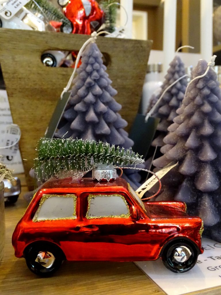 Christbaumanhänger mit rotem Auto und Tannenbaum am Dach gibt es bei Stielreich in 1070 Wien.