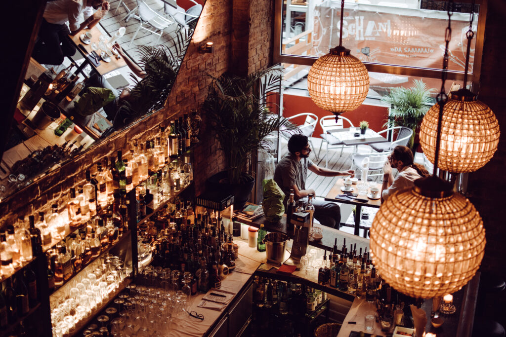 Den Barbereich des Agent Oscar mit seinen hohen Backsteinwänden zieren drei Kristallkugel-Lampen. Hier genießt man seinen Cocktail besonders. Foto: Chiara Milo