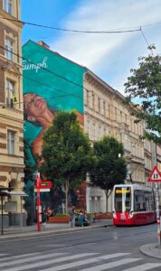 Der Siebensternpark befindet sich eingerahmt von zwei Häusern auf der Siebensterngasse bei der Straßenbahnstation 49. Davor steht ein offener Bücherschrank – also gleich ein ausgelesenes Buch reinstellen und ein anderes mitnehmen. Foto: © Veronika Fischer