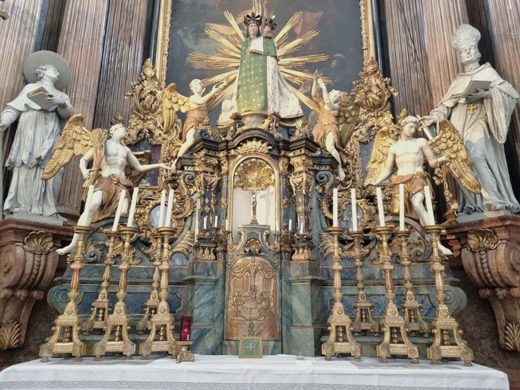Auf dem Hochaltar in der Ulrichskirche stehen hohe Kerzenhalter. Foto: © Christian Scherl