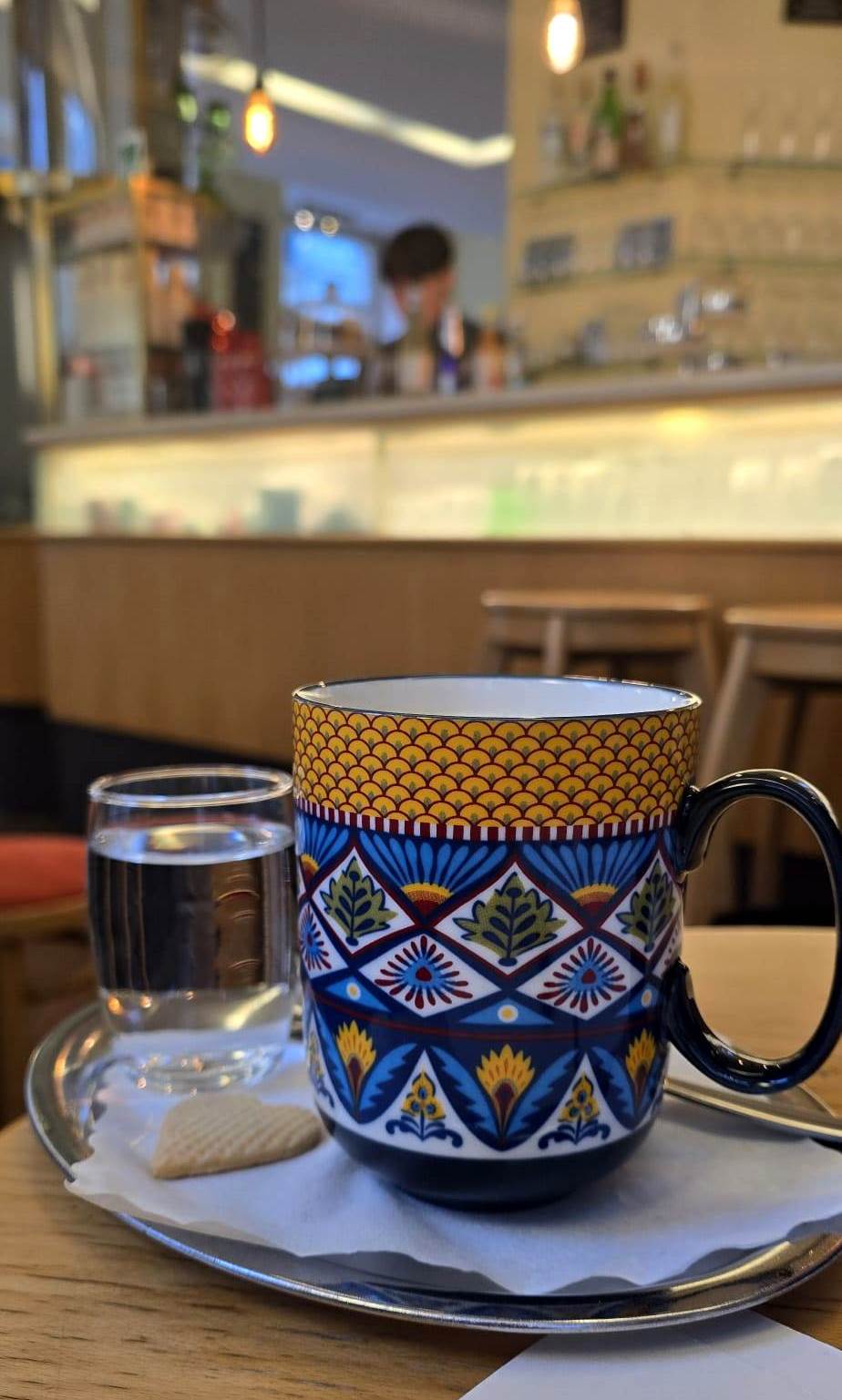 Den Häferlkaffee mit Hafermilch haben wir ganz Wiener-Kaffeehaus-like mit einem Glas Wasser bekommen. Ein Kekserl aus der hauseigenen Backstube darf bei froemmel's auch nicht fehlen. © Veronika Fischer